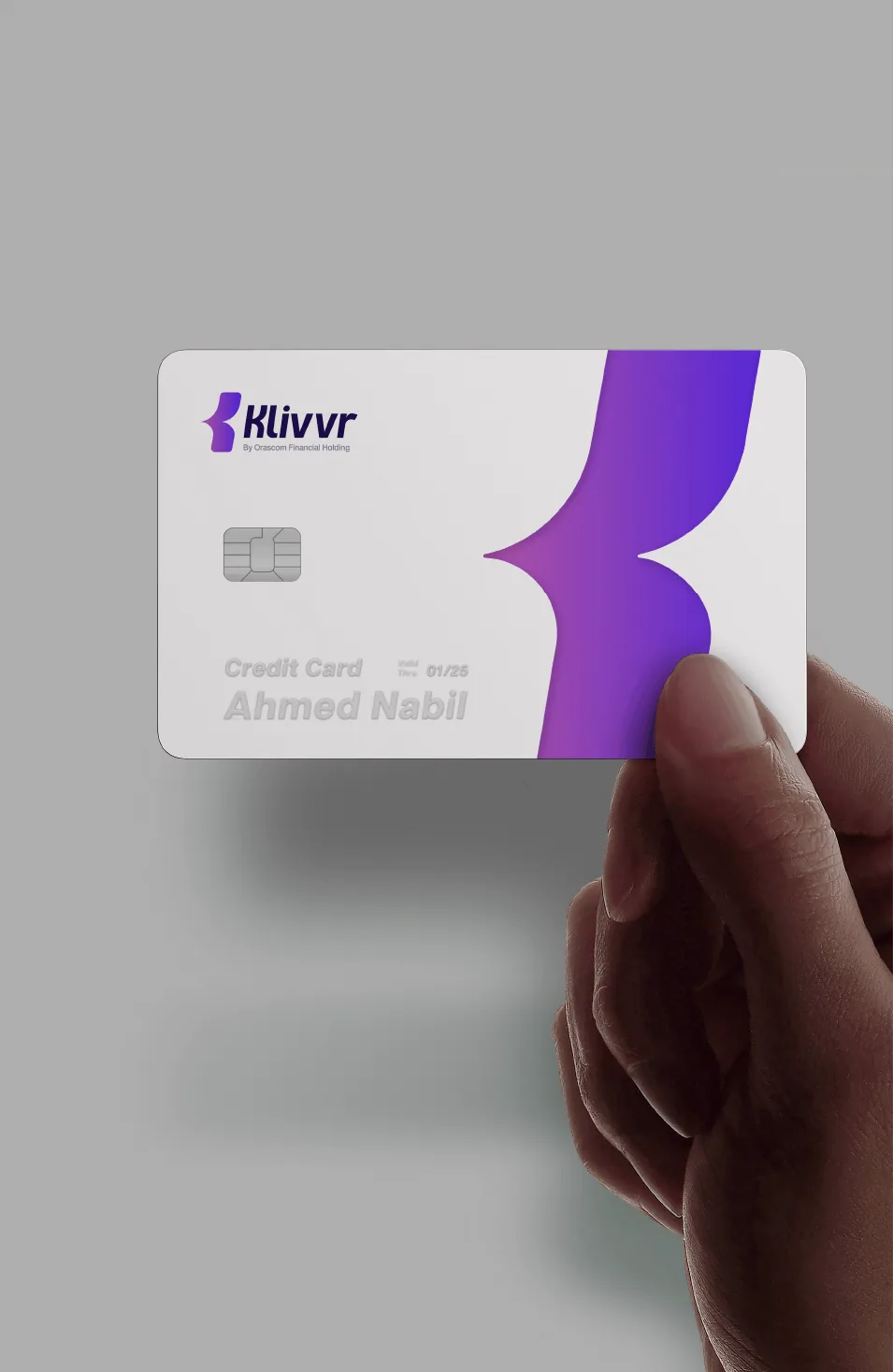 Hand holding a white Klivvr credit card with an embossed gradient K mark