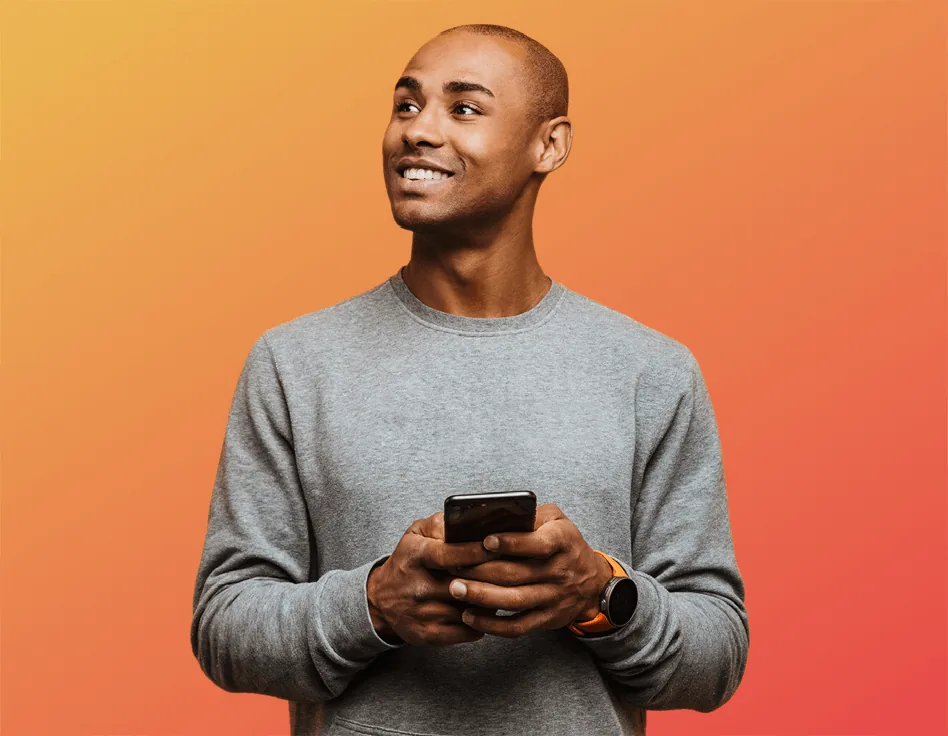 Man smiling while using his phone, representing Klivvr's everyday banking experience