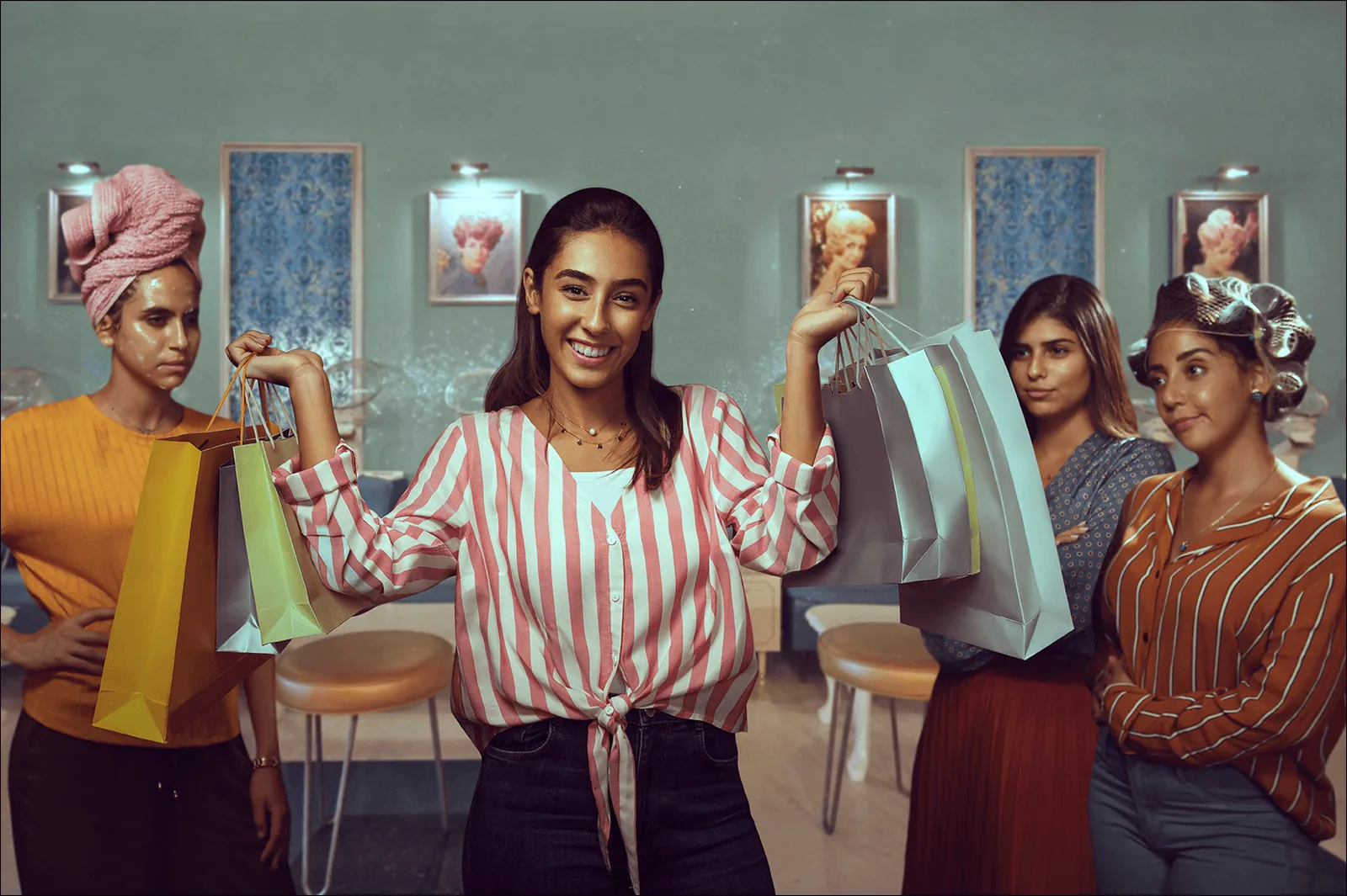 Woman celebrating with shopping bags raised, the full salon cast behind her