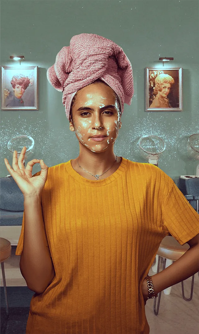 Woman with a face mask and cucumber slices giving a thumbs up